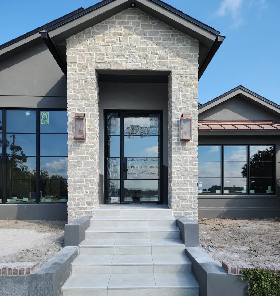 Front entry steps on a new build, poured in concrete and capped with large-format porcelain treads between stucco cheek walls