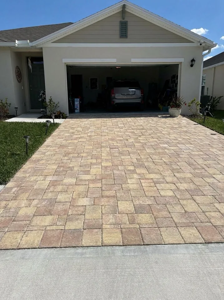 Color concept rendering of the same driveway in a tan blend, meeting a poured concrete apron at the street